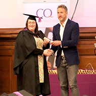 Image: graduate collects scroll from Ben Fogle